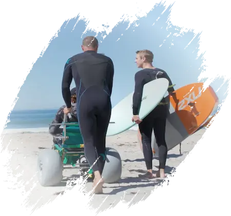 A Better Option John and another man wearing wetsuits and carrying surfboards while walking on a beach toward the ocean.